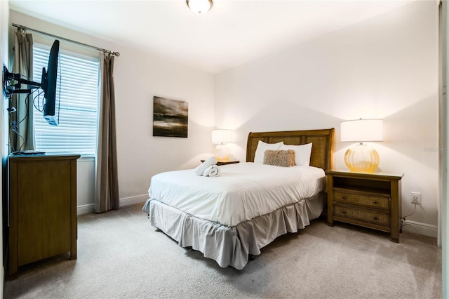 bedroom featuring baseboards and light colored carpet