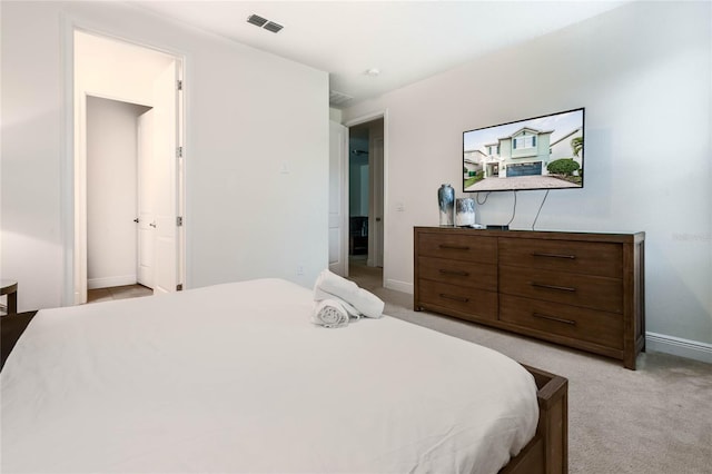 bedroom with baseboards, visible vents, and light colored carpet