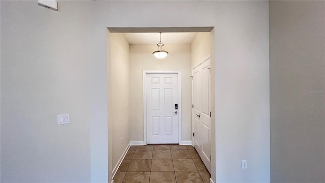 doorway to outside featuring dark tile patterned flooring