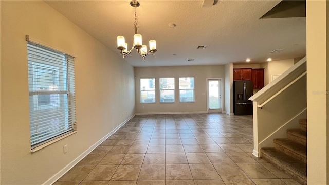 interior space with a notable chandelier and a textured ceiling