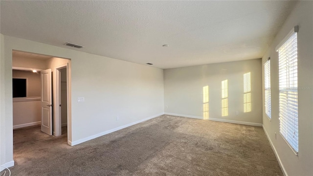 unfurnished room with a textured ceiling and carpet