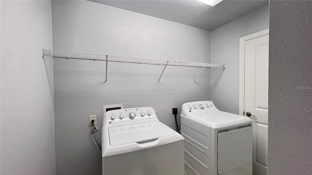 washroom featuring separate washer and dryer and a textured ceiling