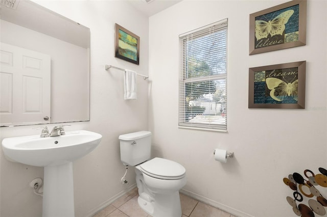 bathroom with sink, toilet, and tile patterned flooring