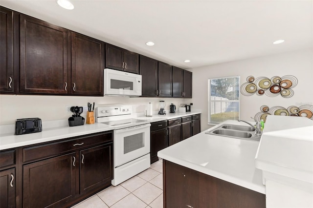 kitchen featuring dark brown cabinetry, light tile patterned flooring, sink, and white appliances