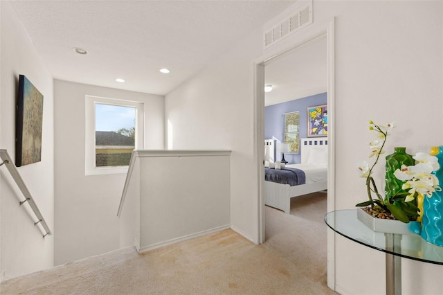 hallway featuring light colored carpet