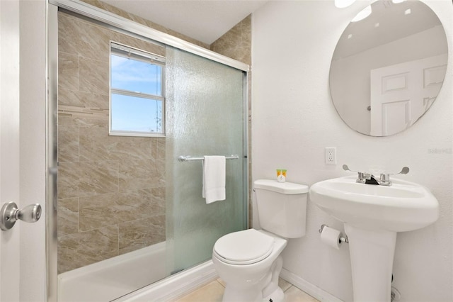 bathroom with toilet, a shower with shower door, and sink