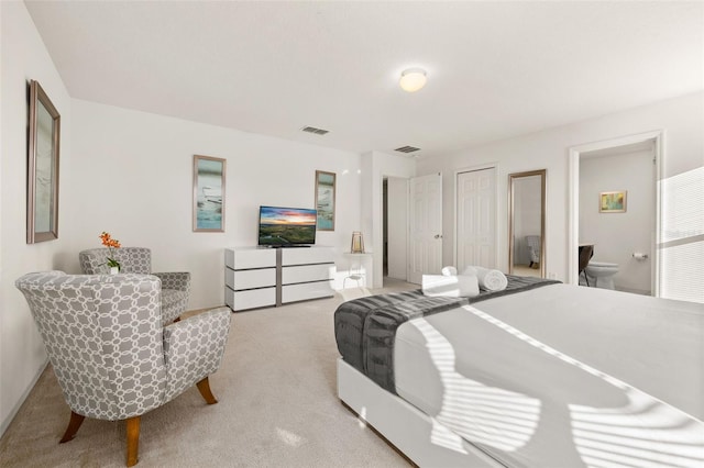 bedroom featuring light colored carpet and ensuite bathroom