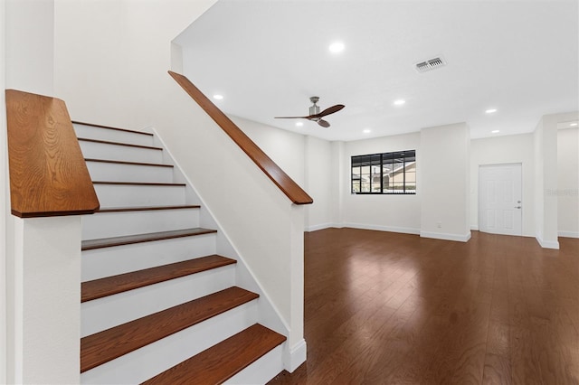 staircase with hardwood / wood-style flooring and ceiling fan