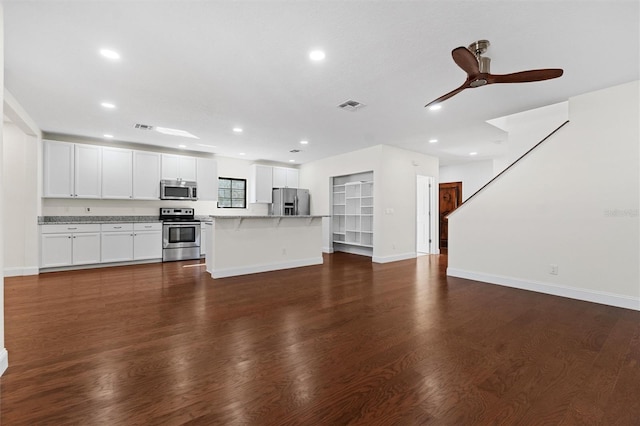 unfurnished living room featuring dark hardwood / wood-style floors and ceiling fan