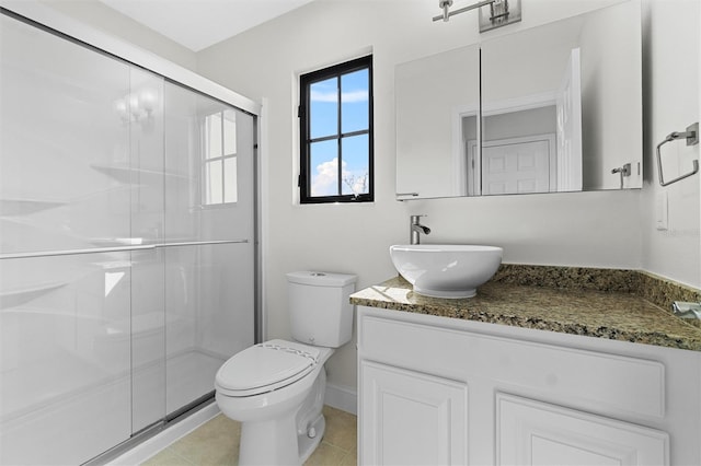 bathroom with vanity, tile patterned floors, a shower with door, and toilet