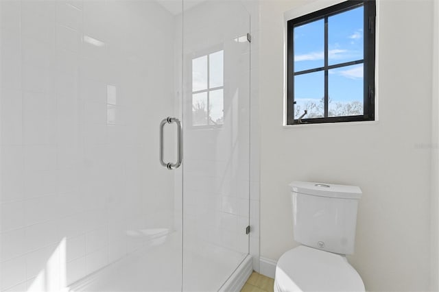 bathroom featuring toilet and a shower with shower door