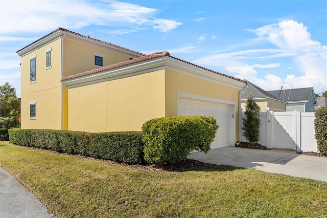 view of side of property featuring a garage and a yard