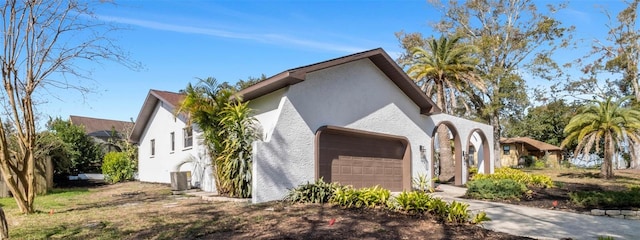 view of front of house featuring a garage and central AC