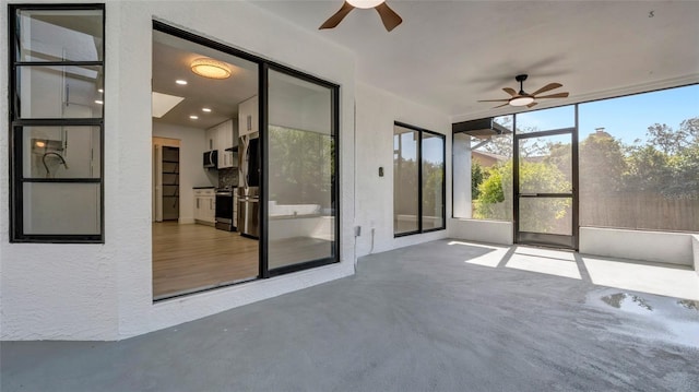 unfurnished sunroom featuring ceiling fan