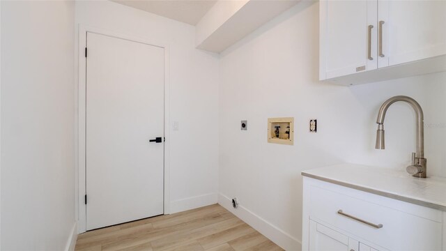 laundry area featuring cabinets, electric dryer hookup, washer hookup, and light hardwood / wood-style flooring