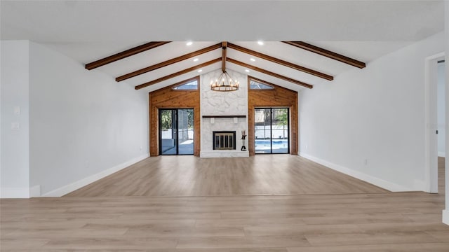 unfurnished living room featuring beam ceiling, plenty of natural light, and an inviting chandelier