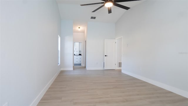 empty room featuring high vaulted ceiling, ceiling fan, and light hardwood / wood-style flooring