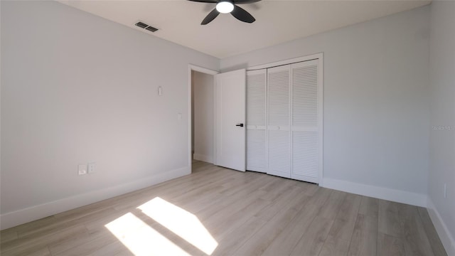 unfurnished bedroom featuring ceiling fan, a closet, and light hardwood / wood-style flooring