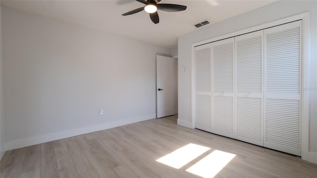 unfurnished bedroom featuring ceiling fan, light hardwood / wood-style floors, and a closet