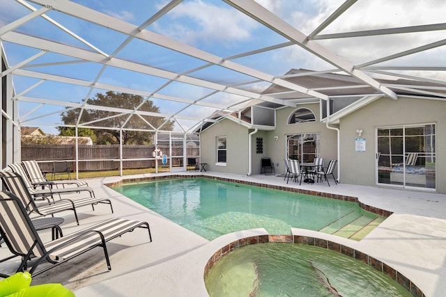 view of swimming pool featuring an in ground hot tub, a patio area, and glass enclosure