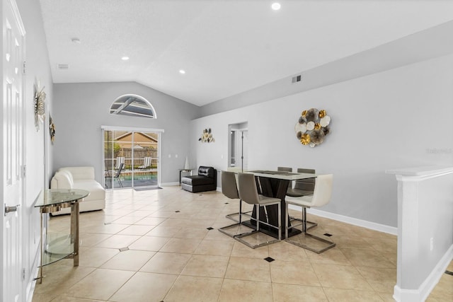 dining room with lofted ceiling, light tile patterned floors, and a textured ceiling