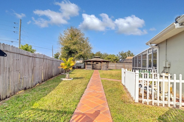 view of yard featuring a gazebo and glass enclosure