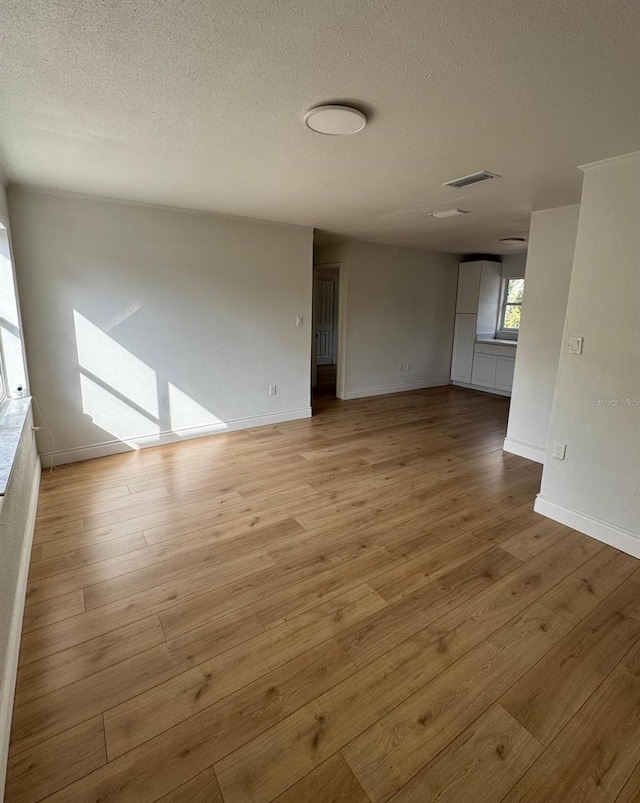 unfurnished room featuring a textured ceiling and light wood-type flooring