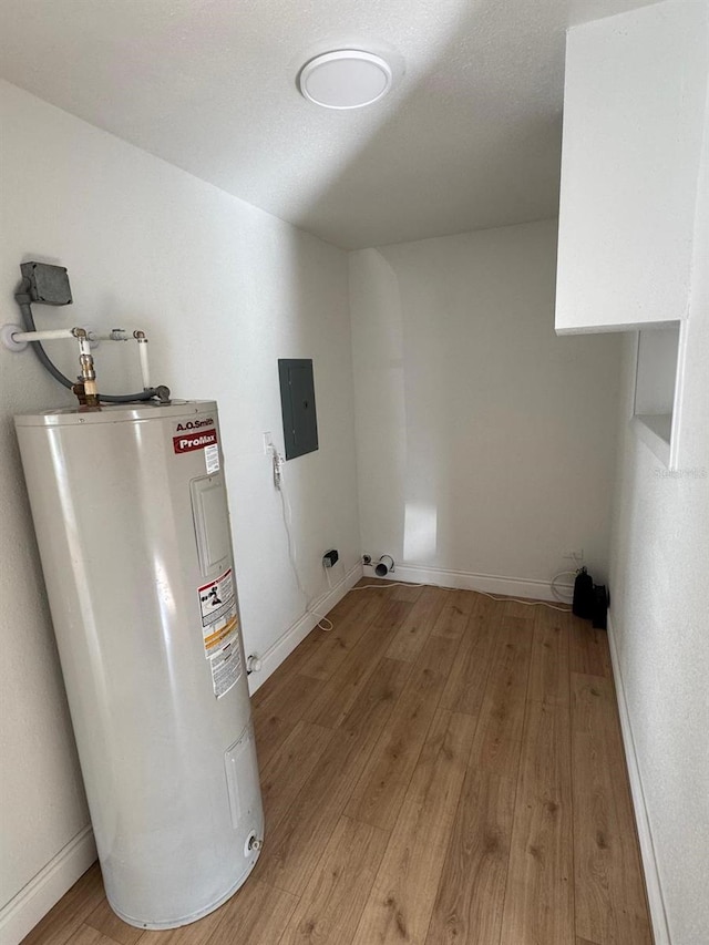 washroom with light hardwood / wood-style flooring, electric panel, and electric water heater