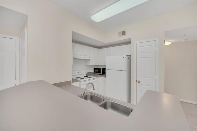 kitchen featuring white cabinetry, sink, white appliances, and kitchen peninsula