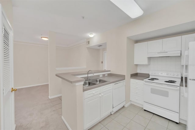 kitchen with sink, white appliances, kitchen peninsula, and white cabinets