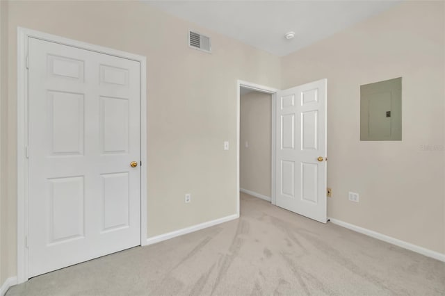 unfurnished bedroom with light carpet and electric panel