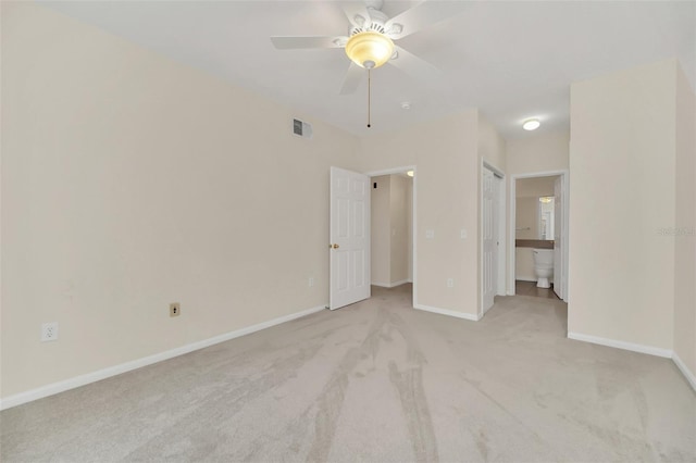 unfurnished bedroom with light colored carpet, ceiling fan, and ensuite bathroom