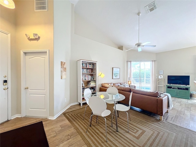 living room featuring high vaulted ceiling, ceiling fan, and light wood-type flooring