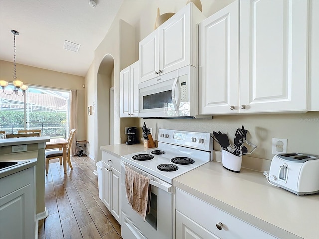 kitchen featuring hanging light fixtures, a notable chandelier, white cabinets, and white appliances