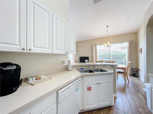 kitchen featuring sink, dishwasher, white cabinetry, decorative light fixtures, and kitchen peninsula