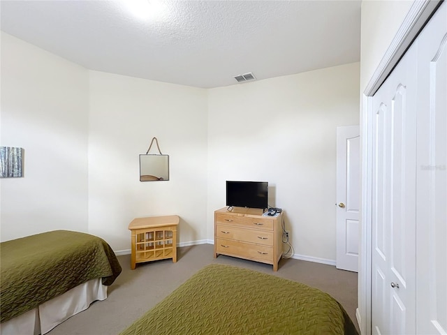 carpeted bedroom featuring a textured ceiling