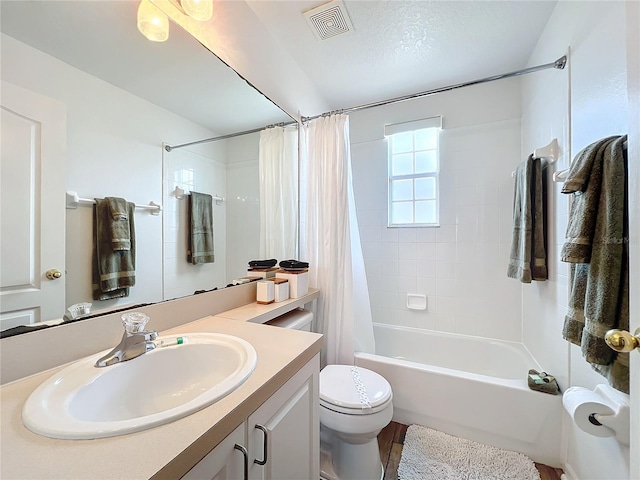 full bathroom with shower / bath combination with curtain, vanity, toilet, and a textured ceiling