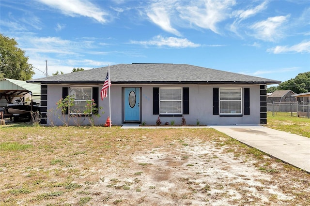 ranch-style home featuring a carport and a front lawn