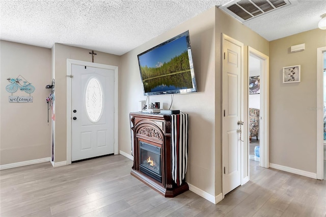 entryway featuring light hardwood / wood-style flooring and a textured ceiling