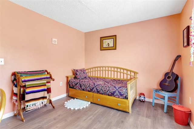 bedroom featuring wood-type flooring and a textured ceiling