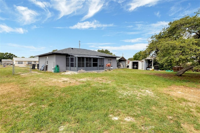 rear view of property with a yard and a sunroom