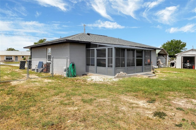 back of house featuring a sunroom and a lawn