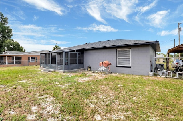 back of property featuring a sunroom and a lawn