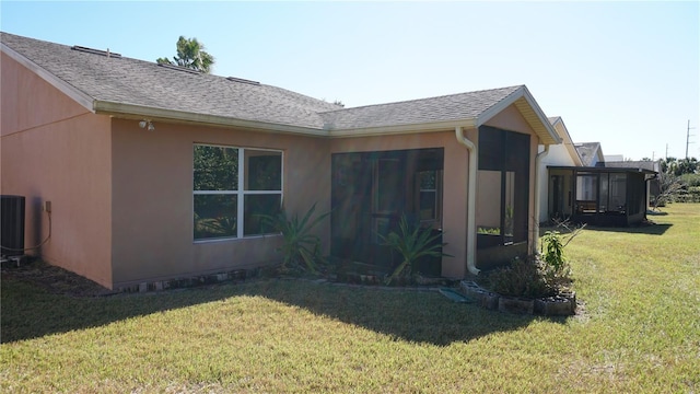 view of home's exterior featuring a sunroom, a yard, and central AC unit