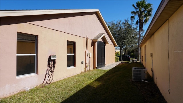 view of home's exterior featuring cooling unit and a lawn