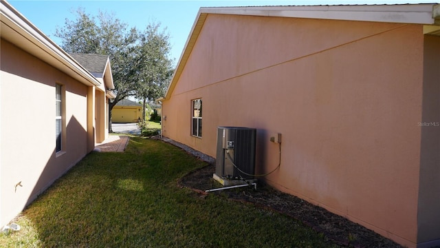 view of property exterior with a yard and central AC