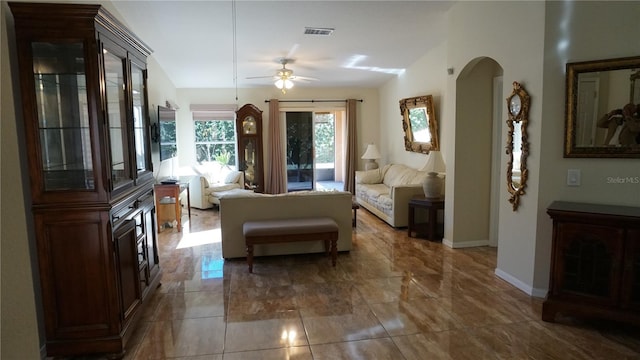 living area with ceiling fan and vaulted ceiling