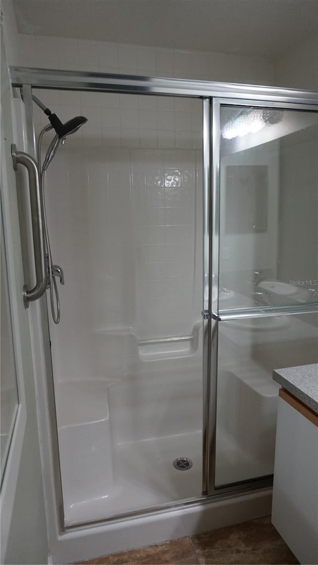 bathroom with vanity and a shower with door