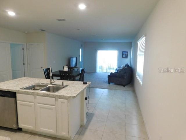 kitchen featuring sink, dishwasher, white cabinets, and a center island with sink