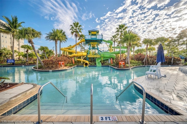 view of swimming pool with a water slide and a patio area